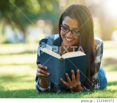 Happy woman, student and reading book on green grass for literature, studying or story in nature. Female person, smart or young adult with smile or glasses for chapter, learning or education at park Happy woman, student and reading book on green grass for literature, studying or story in nature. Female person, smart or young adult with smile or glasses for chapter, learning or education at park 113340371