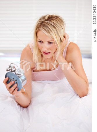 Woman, alarm clock and lazy for waking up in bed, tired and sleepless or fatigue at home. Female person, exhausted and pressing or hit snooze in apartment, frustrated and annoyed or late and anxious Woman, alarm clock and lazy for waking up in bed, tired and sleepless or fatigue at home. Female person, exhausted and pressing or hit snooze in apartment, frustrated and annoyed or late and anxious 113340439