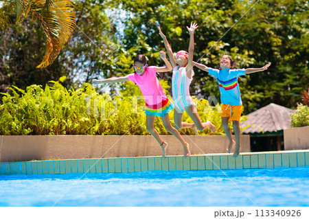 Kids jump into swimming pool. Summer water fun. 113340926