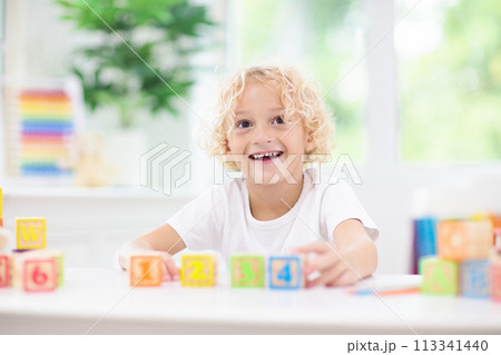Child learning letters. Kid with wooden abc blocks Child learning letters. Kid with wooden abc blocks 113341440