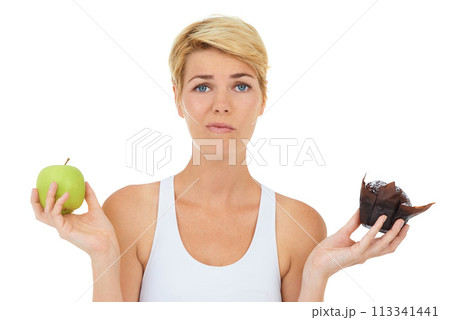 Woman, fitness and health for food doubt, nutrition and decision by studio for lifestyle. Female person, athlete and portrait for diet, workout and white background with apple and cake choice 113341441