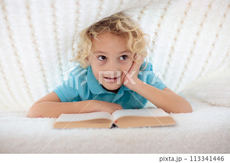 Child reading book in bed. Kids read books. Child reading book in bed. Kids read books. 113341446