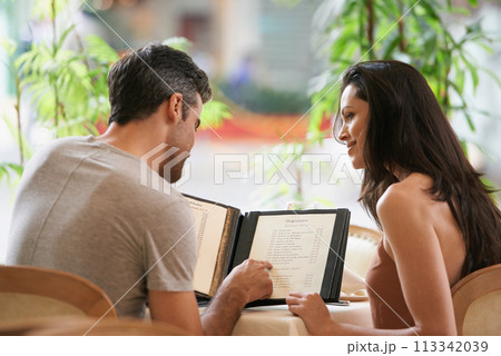 Couple, restaurant and reading a menu for selection, decision and bonding on valentines day. People, back and romance at cafe or lunch choice for anniversary celebration, cuisine and happy at bistro 113342039