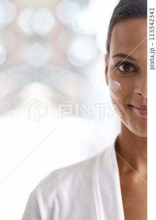 Portrait, skincare and closeup of woman with lotion for dermatology, wellness or beauty in morning. Smile, moisturizer and face of person for cosmetics facial treatment and healthy skin in house. 113342341