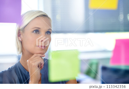 Woman, glass and wall with thinking, planning and notes with reading, proposal and ideas for development. Person, board and paper with brainstorming process, decision and choice with modern office Woman, glass and wall with thinking, planning and notes with reading, proposal and ideas for development. Person, board and paper with brainstorming process, decision and choice with modern office 113342356