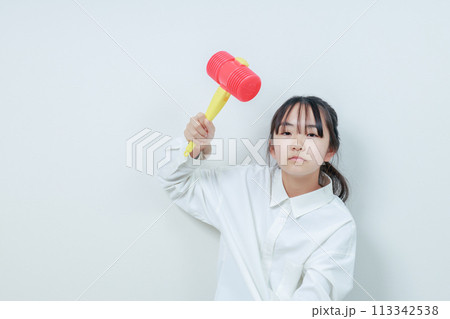 ハンマーを振り翳す怒った表情の女の子 113342538