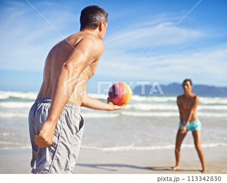 Game, beach and man with woman, volleyball and fitness with wellness and activity for health. Cardio, players and friends with holiday or seaside with water or waves with exercise, summer or training 113342830