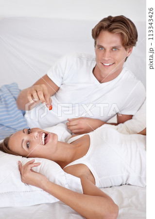 Couple, portrait and eating fruit in bed for romantic morning breakfast, honeymoon or relationship care. Man, woman and berry feed in apartment for hungry or house comfort or food, love or connection Couple, portrait and eating fruit in bed for romantic morning breakfast, honeymoon or relationship care. Man, woman and berry feed in apartment for hungry or house comfort or food, love or connection 113343426
