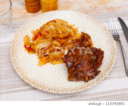 Tasty meat pork served with braised cabbage on served table 113343661