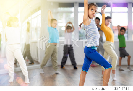 Girl learn to dance modern dances, doing movement with unrecognizable teacher. Girl learn to dance modern dances, doing movement with unrecognizable teacher. 113343731