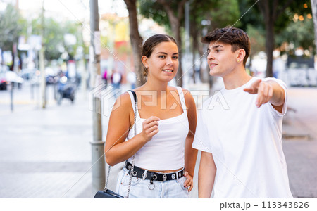 Young couple walking outdoors, pointing finger Young couple walking outdoors, pointing finger 113343826