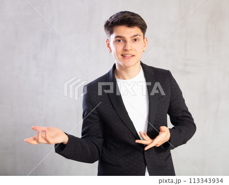 Smiling surprised young male student in suit jacket pointing at you.Portrait of guy pointing finger Smiling surprised young male student in suit jacket pointing at you.Portrait of guy pointing finger 113343934