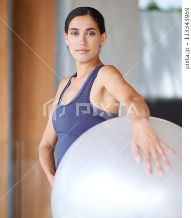 Woman, portrait and exercise with ball for workout, training or health and wellness at home. Face of active female person or young yogi with gym equipment for pilates, fitness or warm up at the house 113343969