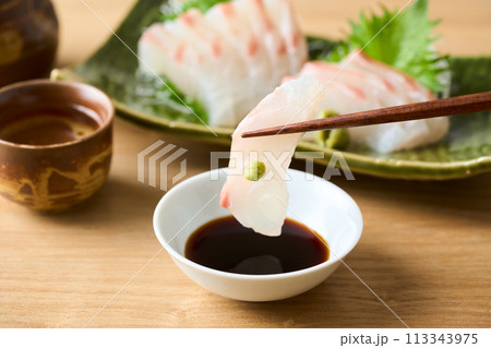 真鯛の刺身を醤油に漬ける 真鯛の刺身を醤油に漬ける 113343975