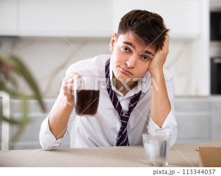 young man suffering from hangover young man suffering from hangover 113344037