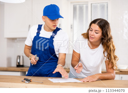 Young woman signs a contract for the provision of services to a plumber 113344070