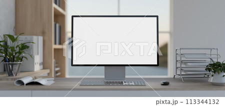 A front view of a PC computer mockup and office supplies on a table in a modern white office. A front view of a PC computer mockup and office supplies on a table in a modern white office. 113344132