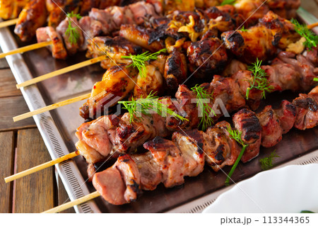Closeup of grilled chicken and pork skewers Closeup of grilled chicken and pork skewers 113344365
