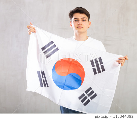 Focused young guy holding South Korea flag 113344382