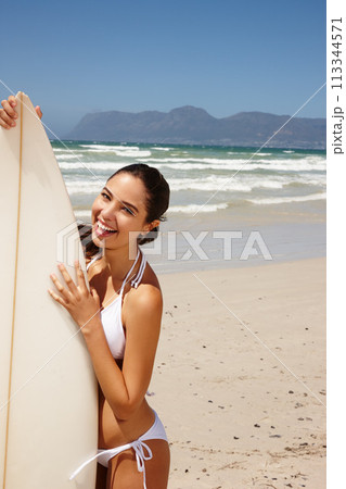 Woman, beach and surfboard for surfing or portrait with happiness, adventure and bikini with blue sky. Tourist, person and surfer by ocean in morning for holiday, vacation and freedom in California 113344571