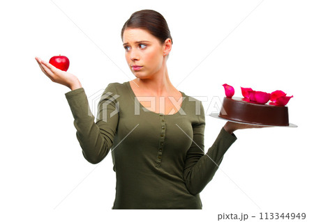 Woman, apple and cake for choice in studio with options, thinking and ideas for diet by white background. Girl, person and model with dessert, fruit and decision for health, wellness and nutrition 113344949