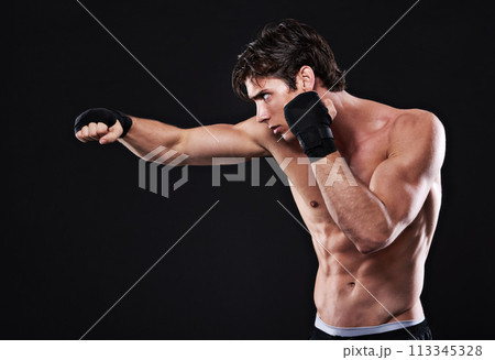 Fitness, boxing and man punching in studio for exercise, challenge or competition training for gym. Power, muscle or serious champion boxer at mma workout with confidence, fight and black background Fitness, boxing and man punching in studio for exercise, challenge or competition training for gym. Power, muscle or serious champion boxer at mma workout with confidence, fight and black background 113345328