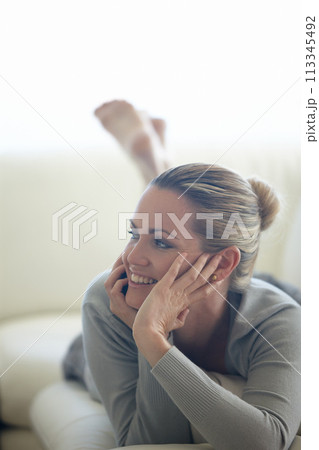 Thinking, happy woman or phone call on sofa in home talking or speaking in living room for communication. Ideas, mobile or person with smile in conversation to relax on couch in a house for a break 113345492