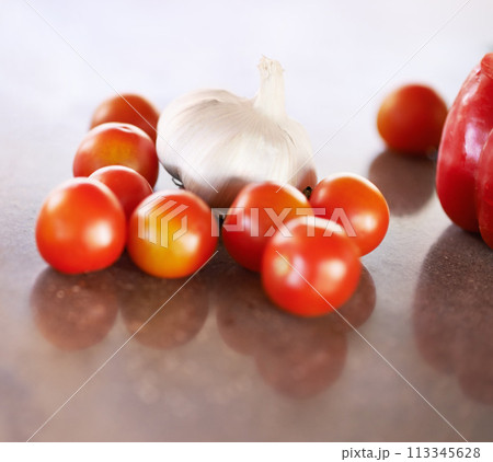 Kitchen counter, home and vegetable recipe to cook for healthy, meal and nutrition for wellbeing and diet. House, fresh and organic food for dinner with tomato and garlic to prepare for soup. 113345628