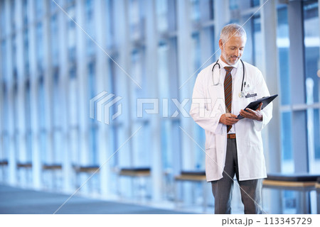 Checklist, happy doctor and man reading in hospital for healthcare, wellness and notes. Clipboard, medical professional and smile of mature surgeon with paper, results and report on chart in clinic 113345729