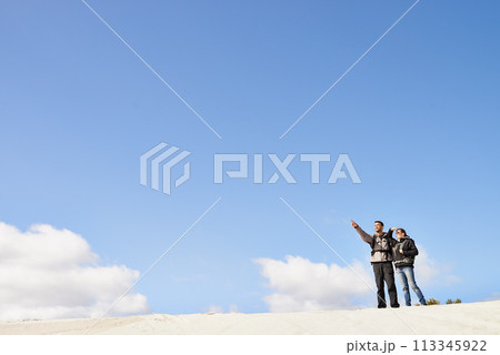 sand dunes, space and couple hiking for adventure, desert and travel on outdoor holiday for love or view. Sky mockup, explorers trip and nomad people pointing in Sahara terrain, nature or dry climate sand dunes, space and couple hiking for adventure, desert and travel on outdoor holiday for love or view. Sky mockup, explorers trip and nomad people pointing in Sahara terrain, nature or dry climate 113345922
