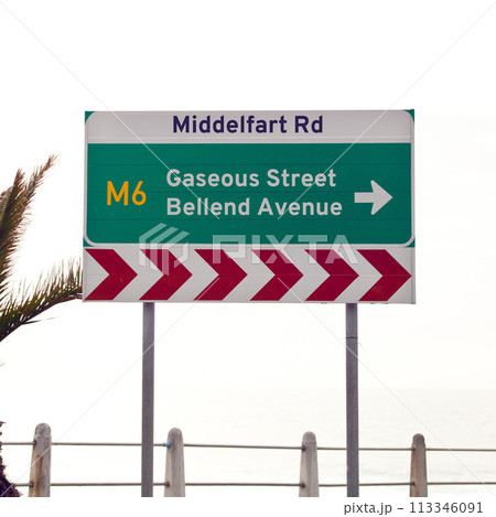 Road sign, intersection and direction in city with arrow for grammar, mistake or text for gas for driving in neighborhood. Buildings, error and funny signage with joke, fart and warning in Cape Town 113346091