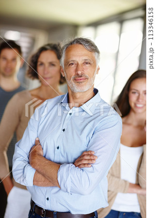 Teamwork, portrait and senior businessman in office, leader or CEO in workplace with team. Face, smile and manager with management at design business firm, collaboration and professional company 113346158