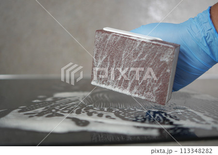 Top view Cleaning a ceramic electric stove with a metal scraper.  113348282
