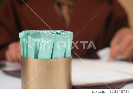 white sugar in a paper packet on table  113348733