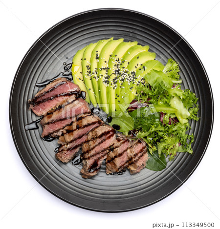 grilled cooked piece of tuna fillet with sliced avocado and salad on black ceramic plate grilled cooked piece of tuna fillet with sliced avocado and salad on black ceramic plate 113349500
