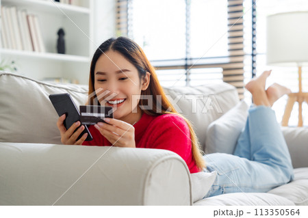 Young asian woman lying on sofa in living room Young asian woman lying on sofa in living room 113350564