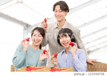 イチゴを持って笑顔を見せる若者たち 113350738