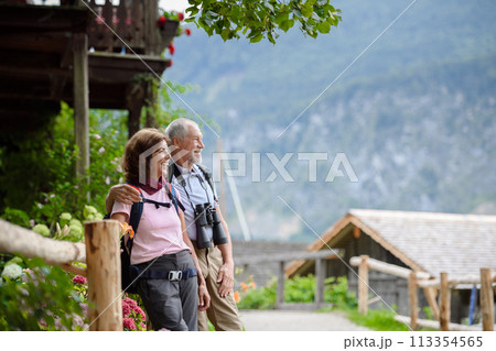Active elderly couple on trip together, during spring day. Senior tourists visiting, exploring new places. Sightseeing, holding hands. 113354565