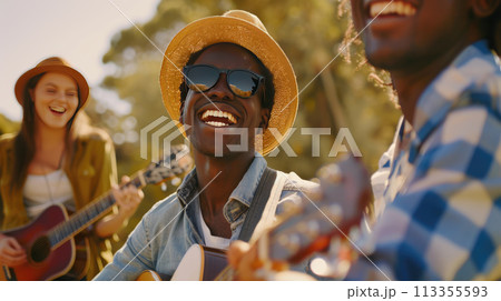 A group of interracial friends having fun with guitar and enjoying music at the park. Summer holidays, outdoor picnic A group of interracial friends having fun with guitar and enjoying music at the park. Summer holidays, outdoor picnic 113355593