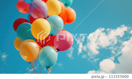 Colorful balloons with string tied together against a blue sky. Helium ballons floating in the air 113355600