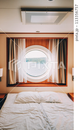 Ship Cabin With Bed And Window With View On Sea. Luxury Cabin On Ferry Boat Or Cruise Liner. Ship Cabin With Bed And Window With View On Sea. Luxury Cabin On Ferry Boat Or Cruise Liner. 113356757