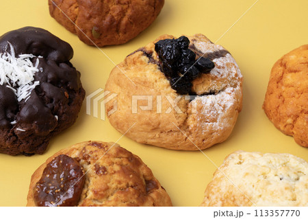 Various delicious scones on a yellow background 113357770
