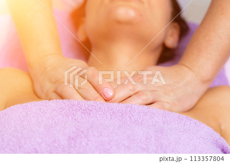 Relaxing massage. European woman getting facial massage in spa salon, side view Relaxing massage. European woman getting facial massage in spa salon, side view 113357804