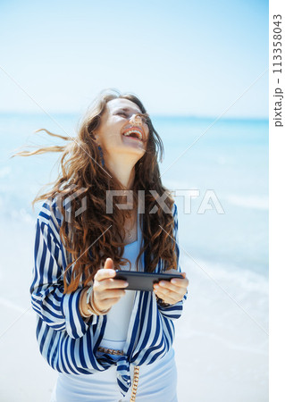 smiling stylish 40 years old woman on seacoast 113358043