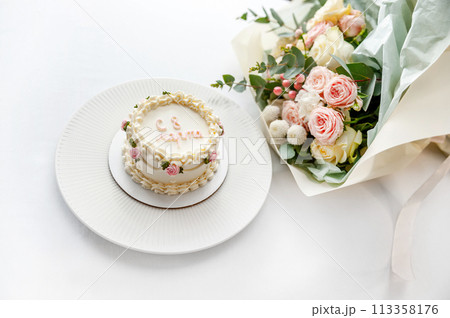 Festive bento cake and bouquet on a light background 113358176