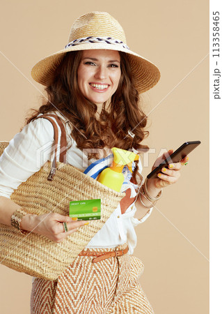 smiling elegant woman in blouse and shorts isolated on beige smiling elegant woman in blouse and shorts isolated on beige 113358465