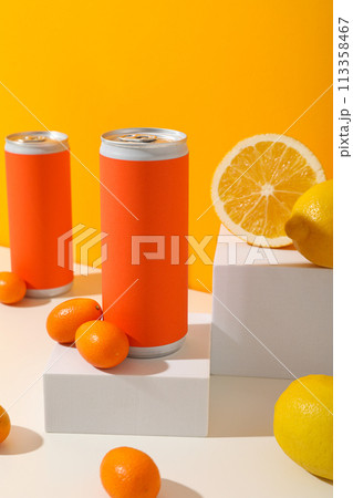 Tin cans and citrus fruits on white blocks on orange background 113358467