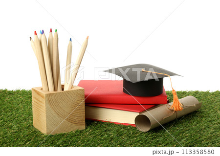 PNG, graduate hat with books on grass, isolated on white background. PNG, graduate hat with books on grass, isolated on white background. 113358580