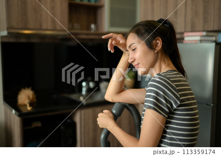 Young housewife wiping sweat from her forehead tired from housework 113359174