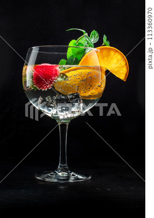Fancy cocktail with fresh fruit. Gin and tonic drink with ice at a party Fancy cocktail with fresh fruit. Gin and tonic drink with ice at a party 113360970
